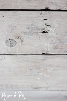 an old white wooden wall with peeling paint