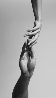 black and white photograph of two hands reaching for each other