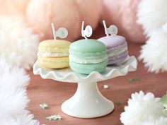 three macaroons are sitting on a cake plate