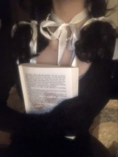 a woman is reading a book with her black cat in front of her and the caption reads, i love cats