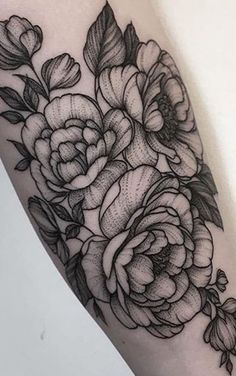 a black and white flower tattoo on the arm