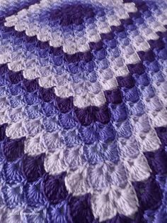 a purple and white crocheted afghan is shown