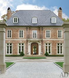 a large red brick house with white trim and arched doorways on the front entrance