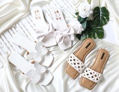 white shoes and flowers are laid out on a bed