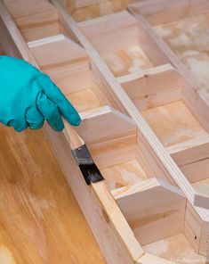 a person in blue glove and green gloves cleaning wooden drawers