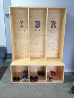 a wooden shelf filled with pairs of shoes and letters that spell out the word i b r