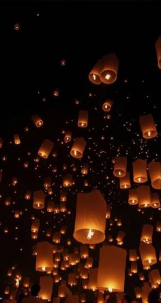 many lanterns are floating in the air at night