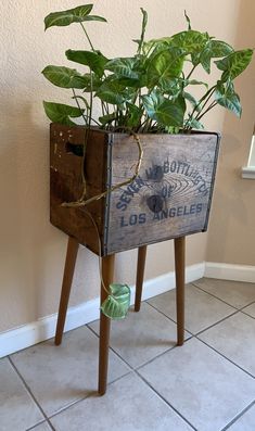 a planter that is sitting on top of a wooden stand with plants in it