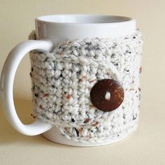 a crocheted coffee cup cozying with a button on the front and inside