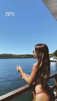 a woman is sitting on a boat looking out at the water