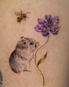 a tattoo with a mouse and flowers on it