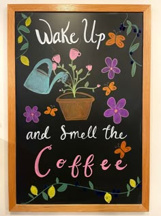 a chalkboard with flowers and watering can on it that says wake up and smell the coffee