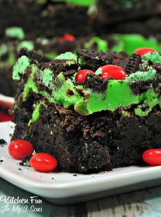 a white plate topped with cake covered in green frosting and red candy candies