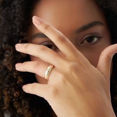 a close up of a person with a ring on their finger and her hand in front of her face