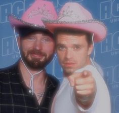 two men in hats pointing at the camera with one man's hand on his hip