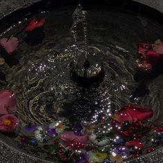 a bowl filled with water and flowers floating on top of it's surface,