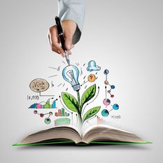 a person holding a pen and pointing at an open book with green plants growing out of it