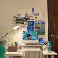 a white desk with a laptop computer on top of it next to a green chair