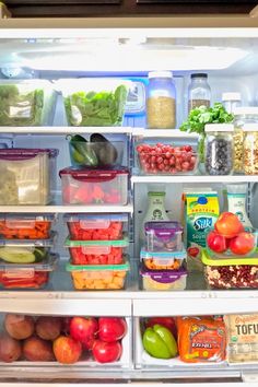 an open refrigerator filled with lots of different types of vegetables and fruits in containers on the shelves