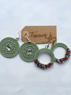 three pairs of beaded hoop earrings and a tag