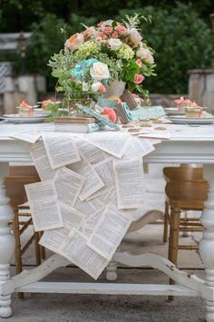 a white table topped with books and flowers