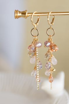 "This beautiful earrings are made from handful of gemstone like Quartz, Amethyst, Amtrine, Rose Quartz, and Pearl in 14K gold filled wires. They are carefully hung on a ring that dangling under a small gold ear hoop. The pictures do not do this earrings justice Let this unique accessory be your everyday adventures or a great gift for the loved one! Because each item is handmade there may be differences from the picture viewed. Each stone/ piece is unique and no two pieces will be exactly alike. Small Gemstone Jewelry, Handmade Stone Earrings, Bead Earrings Ideas, Earring Cluster, Rose Quartz And Pearl, Diy Earrings Dangle, Hoop Earrings Diy, Handmade Dangle Earrings, Unusual Earrings