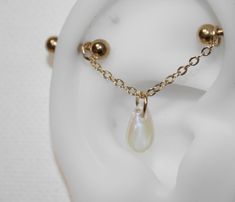 an earring with a chain attached to it and a pearl drop on the end