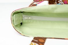 the inside of a purse is shown with an open zippered compartment and floral print fabric