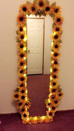 a sunflower decorated mirror with lights in the shape of a frame and flowers around it