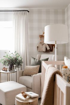 a living room filled with furniture and a baby's crib next to a window