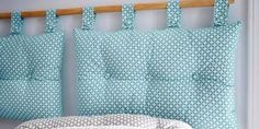 a bed with blue and white bedspread next to a wooden headboard