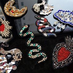 there are many different types of brooches on the table in front of each other