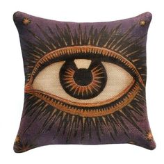 a decorative pillow with an eye design on the front and side, in purple tones