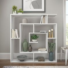 a white shelf filled with vases and books