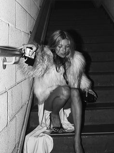 a woman is sitting on the stairs with her purse