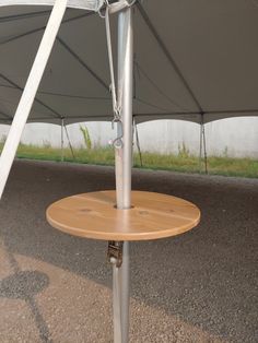 a wooden table sitting under a white tent