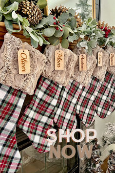 christmas stockings hanging from a mantel in front of a fireplace with pine cones and evergreens