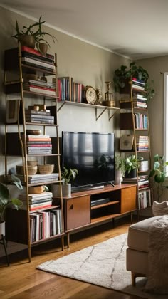 a living room filled with furniture and a flat screen tv sitting on top of a wooden shelf