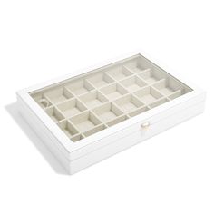 an open white box with many compartments on the bottom and inside, sitting on a white surface