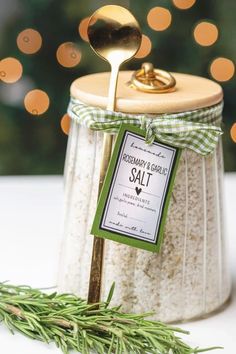 a jar filled with salt and a spoon in it next to a christmas tree branch