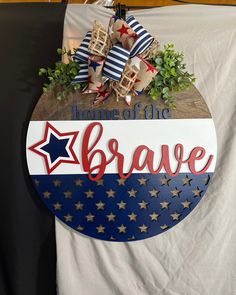 a sign that says, home of the brave with stars and stripes on it in front of a white backdrop