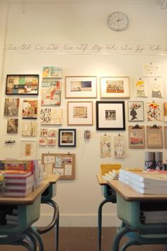 two desks with books and pictures on the wall