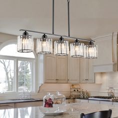 a kitchen island with four lights hanging over it