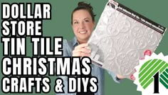 a woman is holding up a christmas craft and diy kit with the words dollar store tin tile in it