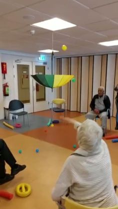 several people are sitting in chairs and playing with balls