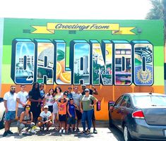 a group of people standing in front of a building with the word orange painted on it