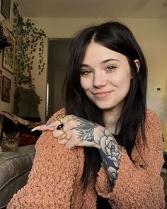 a woman with tattoos on her arm posing for the camera