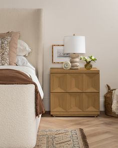 a bedroom with a bed, nightstand and lamp