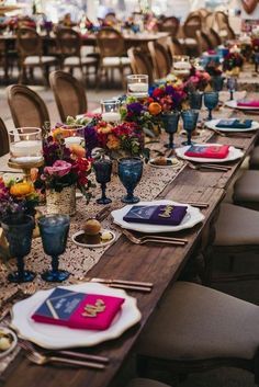 a long table is set with plates and place settings