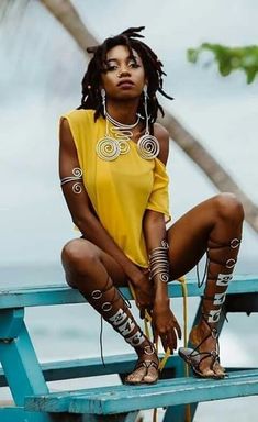 a woman with dreadlocks sitting on a bench